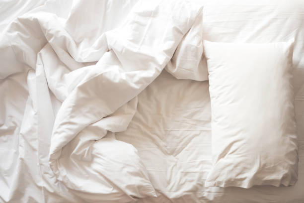 istock Messy bed. White pillow with blanket on bed unmade. Top view. 860112266