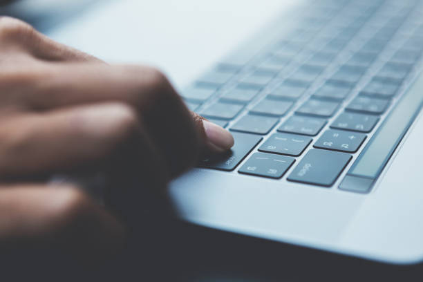 istock Man holding cup of coffee in hand and working with laptop. 860120402