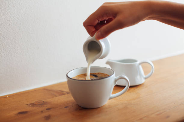 istock Woman hand pouring milk in coffee 860122090