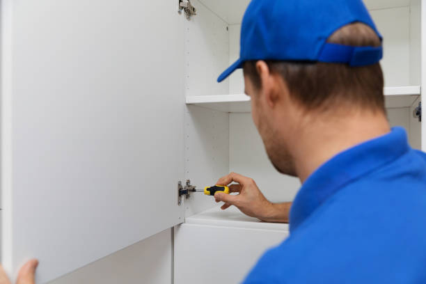 istock worker in blue uniform doing furniture assembly with screwdriver 860129586