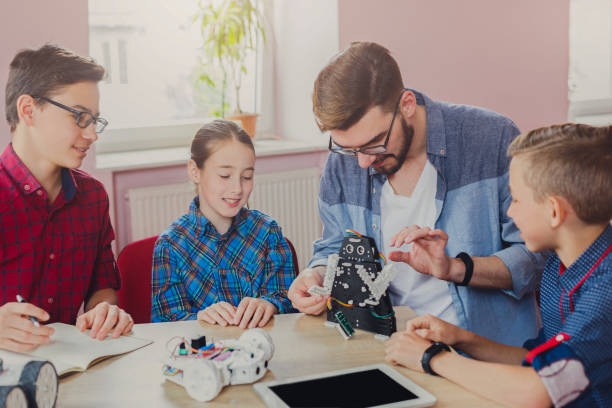 istock Stem education. Kids creating robots with teacher 860136428