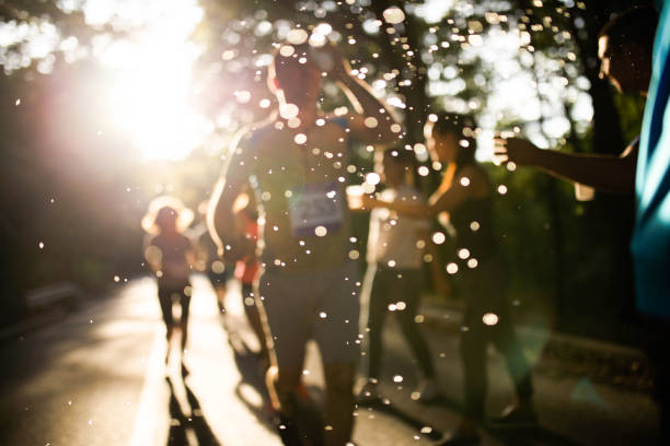 капли воды во время перерыва на освежение марафонской гонки! - distance running фотографии стоковые фото и изображения