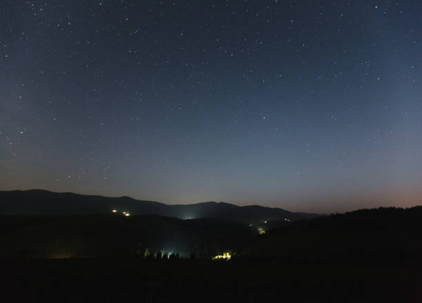 istock Starry sky over the mountains and mountain village. 860141260