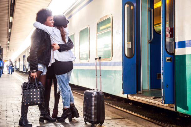 Friends at train station platform, tourist and commuters arriving