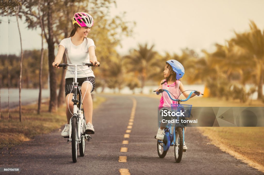 Asian mother and daughter cyclist in the park. Cycling Stock Photo