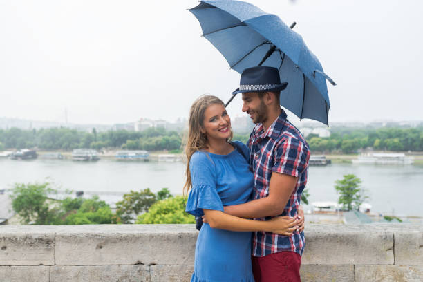 istock Handsome coupleunder the umbrella 860158238