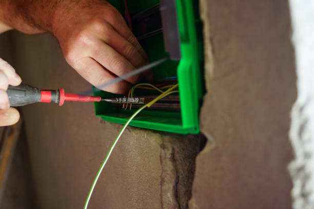 istock Hands electrical wiring is pulled through the hole in the wall of the drywall. 860161216