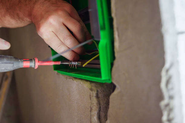 istock Hands electrical wiring is pulled through the hole in the wall of the drywall. 860161454