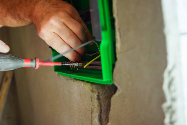 istock Hands electrical wiring is pulled through the hole in the wall of the drywall. 860161494