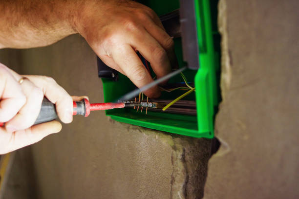 istock Hands electrical wiring is pulled through the hole in the wall of the drywall. 860161548