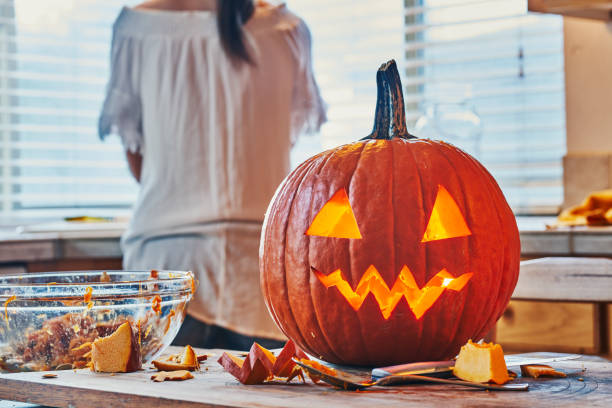 cleaning up after making jack o lantern cleaning up after making jack o lantern pumpkin for halloween on kitchen table halloween pumpkin human face candlelight stock pictures, royalty-free photos & images