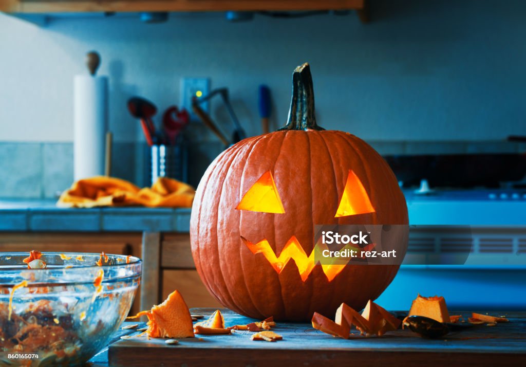 creepy halloween jack o lantern pumpkin creepy Halloween jack o lantern pumpkin in kitchen glowing right after it was carved Jack O' Lantern Stock Photo