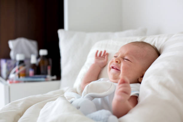 istock Cute baby boy, lying in bed with cold 860168022