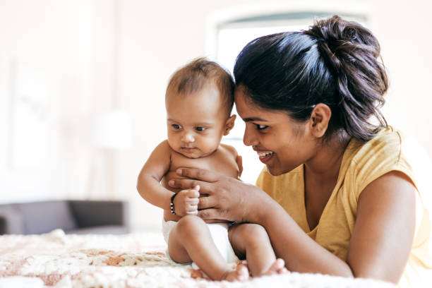 mom and baby indoor - asian and indian ethnicities imagens e fotografias de stock