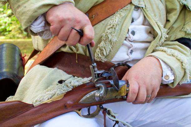 a  revolutionary war re-enactor portraying a militiaman loads his flintlock musket - colonial re enactor imagens e fotografias de stock