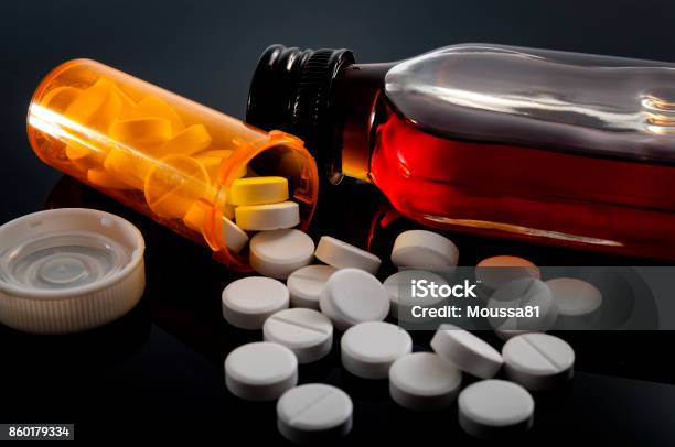 Spilled Opioids And A Flask Of Hard Liquor Stock Photo - Download Image Now - Alcohol - Drink, Medicine, Opioid