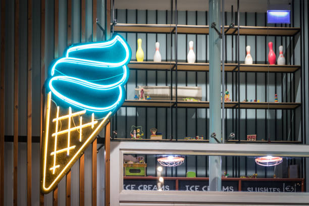 Got Icecream! A big neon icecream sign on a cafe with toys seen in a window. neon sign ice cream stock pictures, royalty-free photos & images