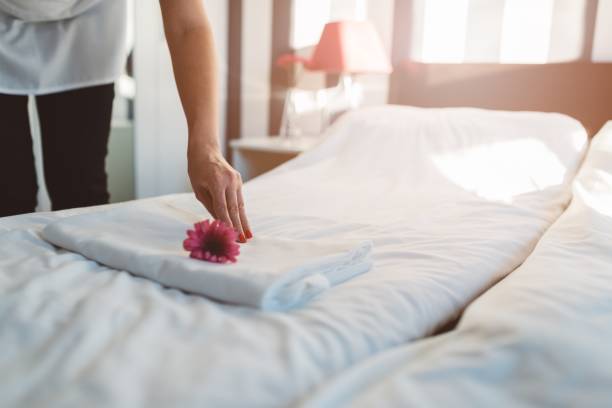 Hotel maid making a bed Hotel maid making a bed and putting flower on towel bed and breakfast stock pictures, royalty-free photos & images