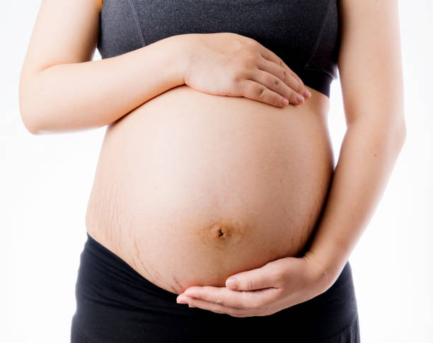 szczęśliwa kobieta w ciąży dotyka brzucha - human pregnancy abdomen naked human hand zdjęcia i obrazy z banku zdjęć