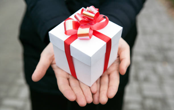 istock Female hands give you a gift box close up 860198856