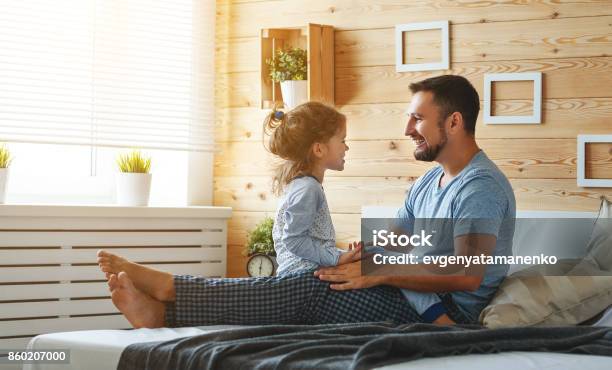 Happy Family Father And Daughter Reading Book In Bed Stock Photo - Download Image Now