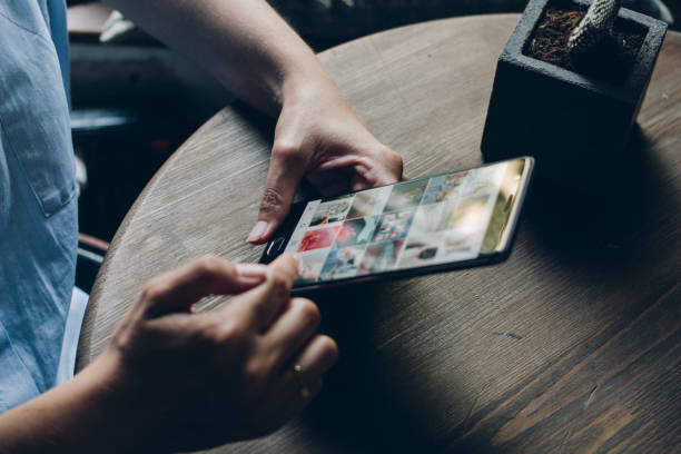 Using Instagram application Moscow, RUSSIA - August 20th, 2017: Young woman holding smartphone with search page screen of Instagram application. Instagram is largest and most popular photograph social networking. editorial stock pictures, royalty-free photos & images