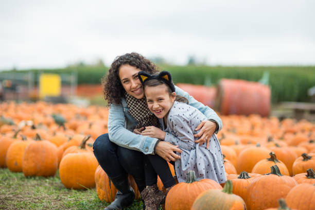 istock Mom and daughter at pumpkin patch farm 860217624