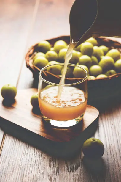 Indian fresh gooseberry juice or stock photo of Amla juice (Phyllanthus emblica) , selective focus