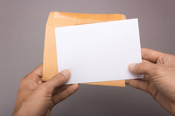 istock Blank postcard and envelope in hands on a gray background. Leaflet A6 mockup 860236206
