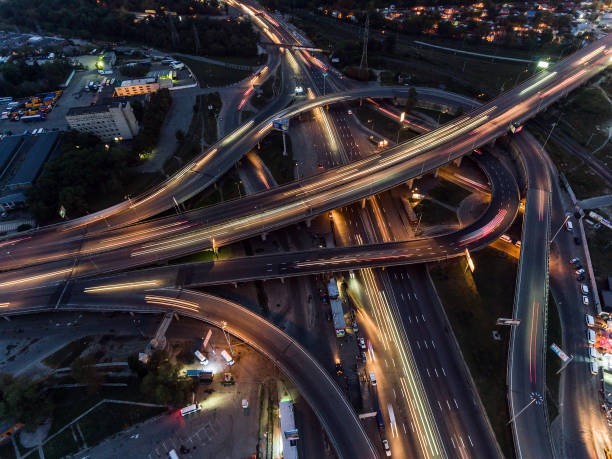 vertical top down aerial view of traffic on freeway interchange at night. - road top view imagens e fotografias de stock