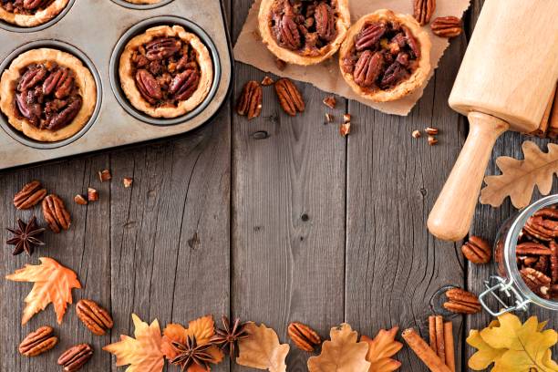 istock Autumn baking scene frame with pecan tarts over wood 860239416