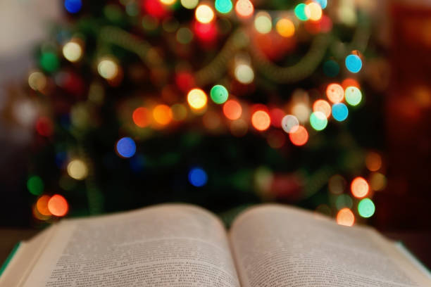 Christmas and bible with blurred candles light background stock photo