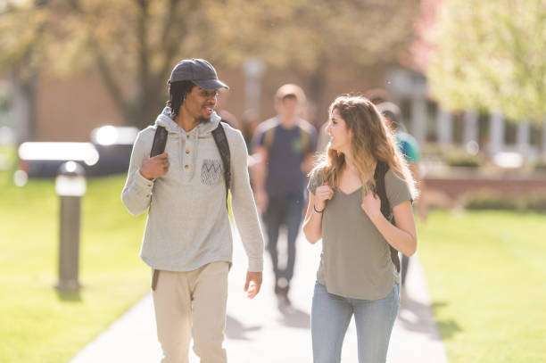 istock College students hang out in between classes on sidewalk, talking and smiling 860242660