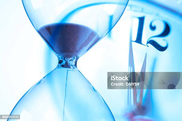 Hourglass And Clock About To Strike Twelve Oclock Stock Photo - Download Image Now - Deadline, Midnight, Hourglass