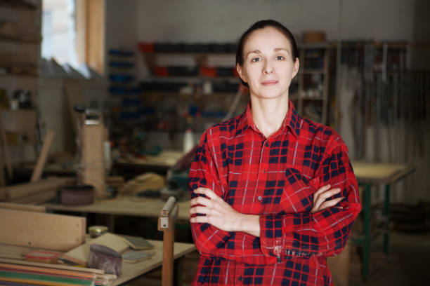 istock Woman carpenter wearing working clothes and smiling in her workshop. 860246966