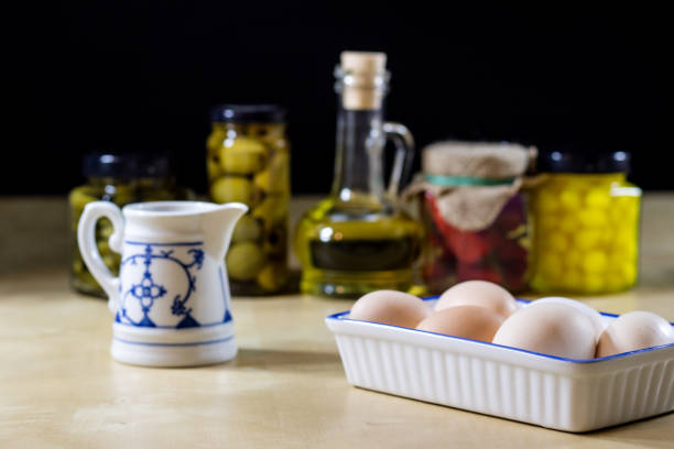 Egg, olive oil, spices on the kitchen table. Wooden table, kitchen, black background.