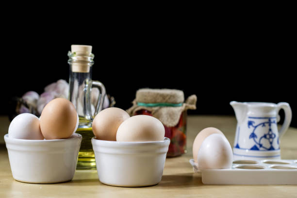 istock Egg, olive oil, spices on the kitchen table. Wooden table, kitchen, black background. 860247854