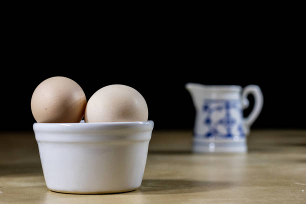 Egg, milk and jug on the kitchen table. Kitchen table with food products. Black background.