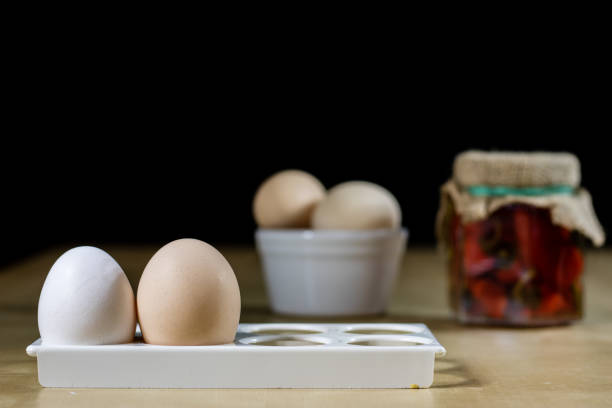 Egg, olive oil, spices on the kitchen table. Wooden table, kitchen, black background.