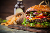 Tasty burgers on wooden table