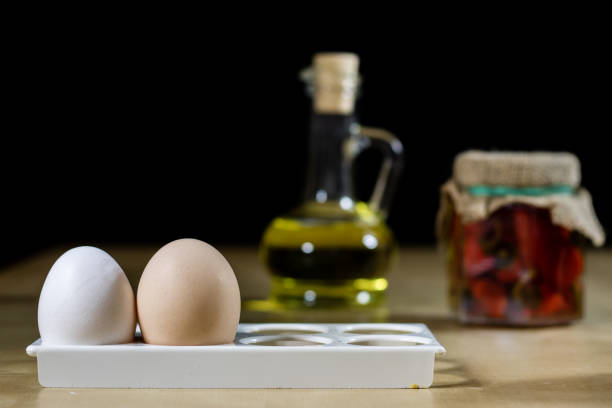 Egg, olive oil, spices on the kitchen table. Wooden table, kitchen, black background.