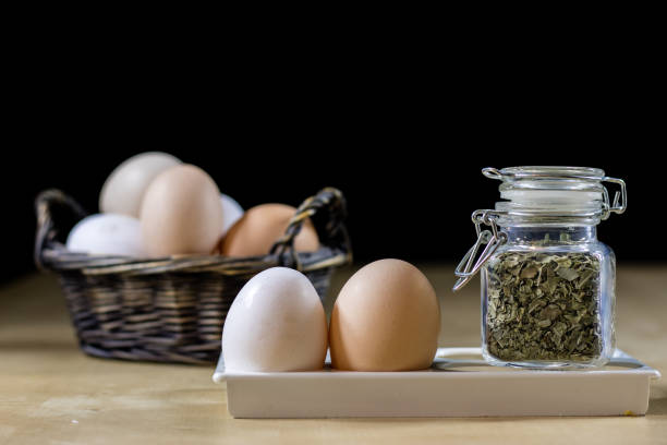 Egg, olive oil, spices on the kitchen table. Wooden table, kitchen, black background.