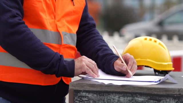 Construction worker taking notes on construction site