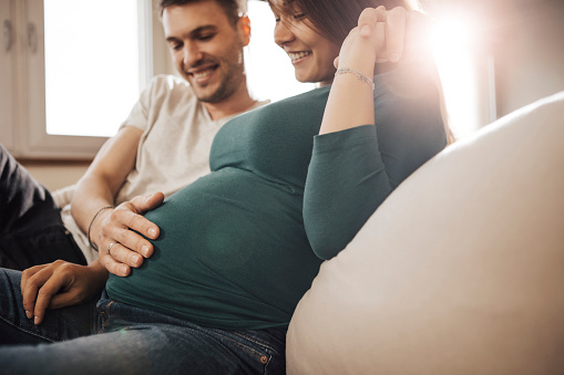 a loving and gentle family. pregnant mom, son sits on dad's shoulders and everyone kisses. the concept of family happiness. medical services for the whole family, family doctor.