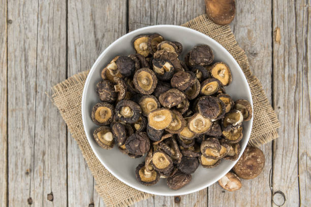 istock Portion of Shiitake mushrooms (dried) on wooden background, selective focus 860268818