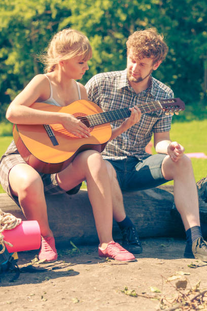 istock Young couple camping playing guitar outdoor 860268826
