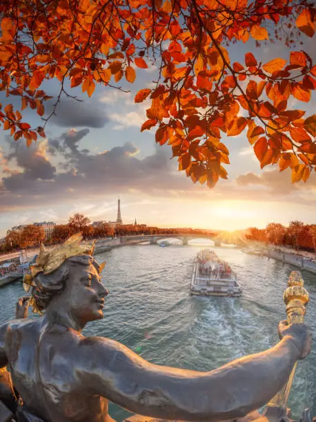 Photo of Alexandre III bridge in Paris against Eiffel Tower with autumn leaves, France