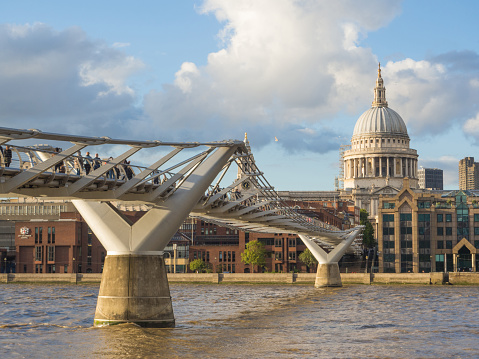 London skyline with a view of St Paul's Cathedral, Millenium Bridge and the River Thames on a sunny afternoon.