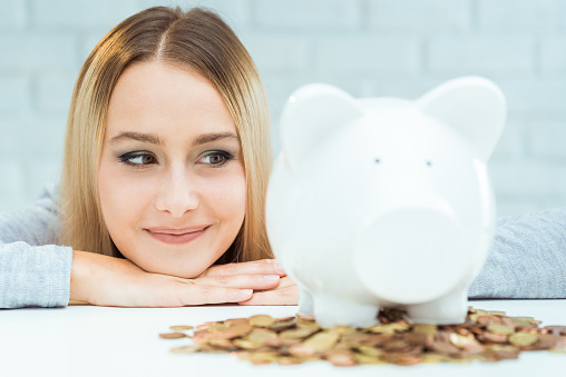 Beautiful woman with piggy bank. Responsible Investing concept.