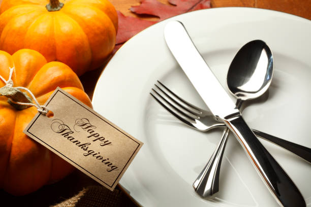istock Happy Thanksgiving Tag Tied To Small Pumpkin At Table Setting 860291128